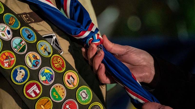 A member of the Boy Scouts of America being given their Eagle Scout neckerchief and slide.