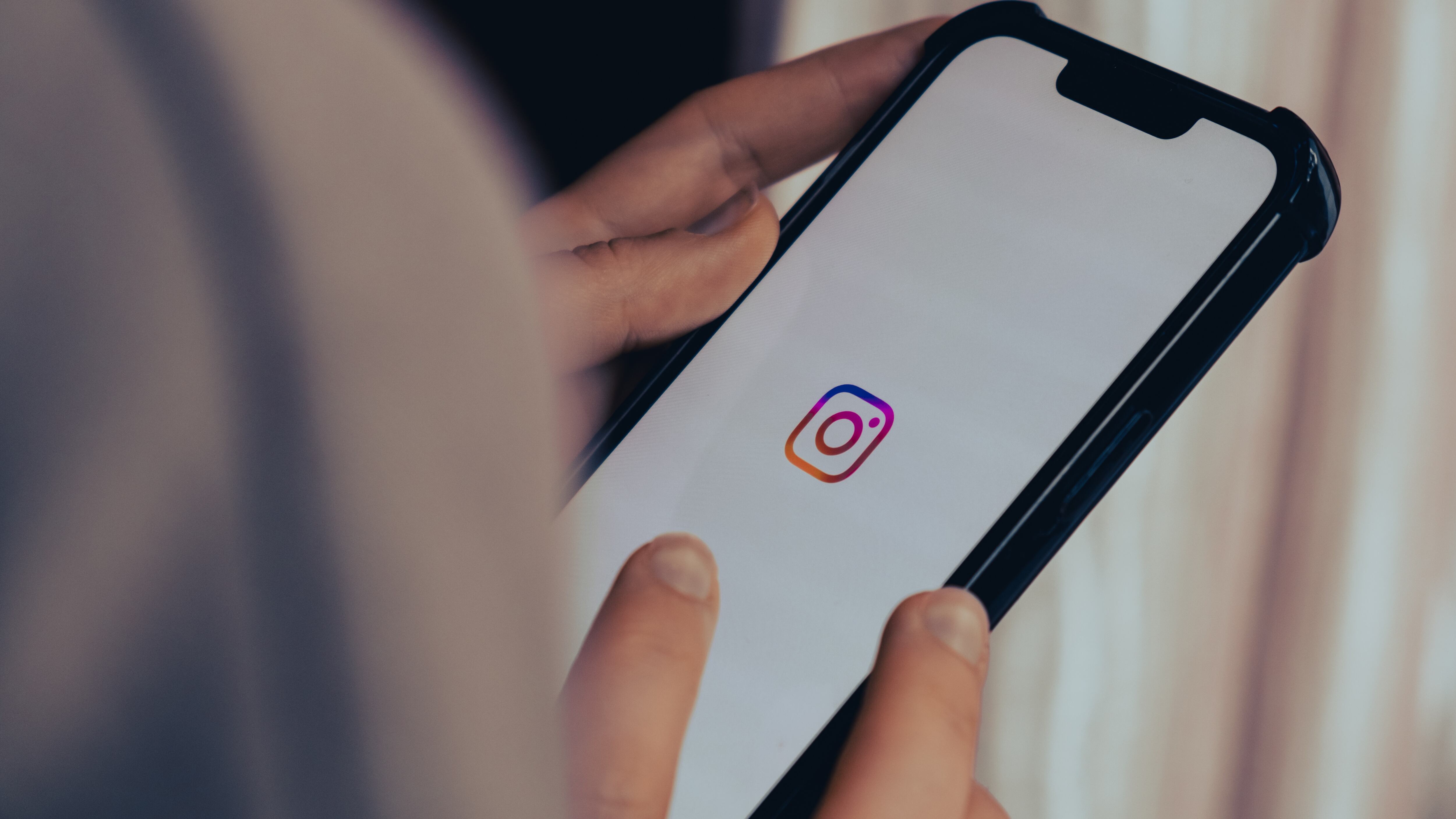 A female hand scrolling social media feed on Instagram