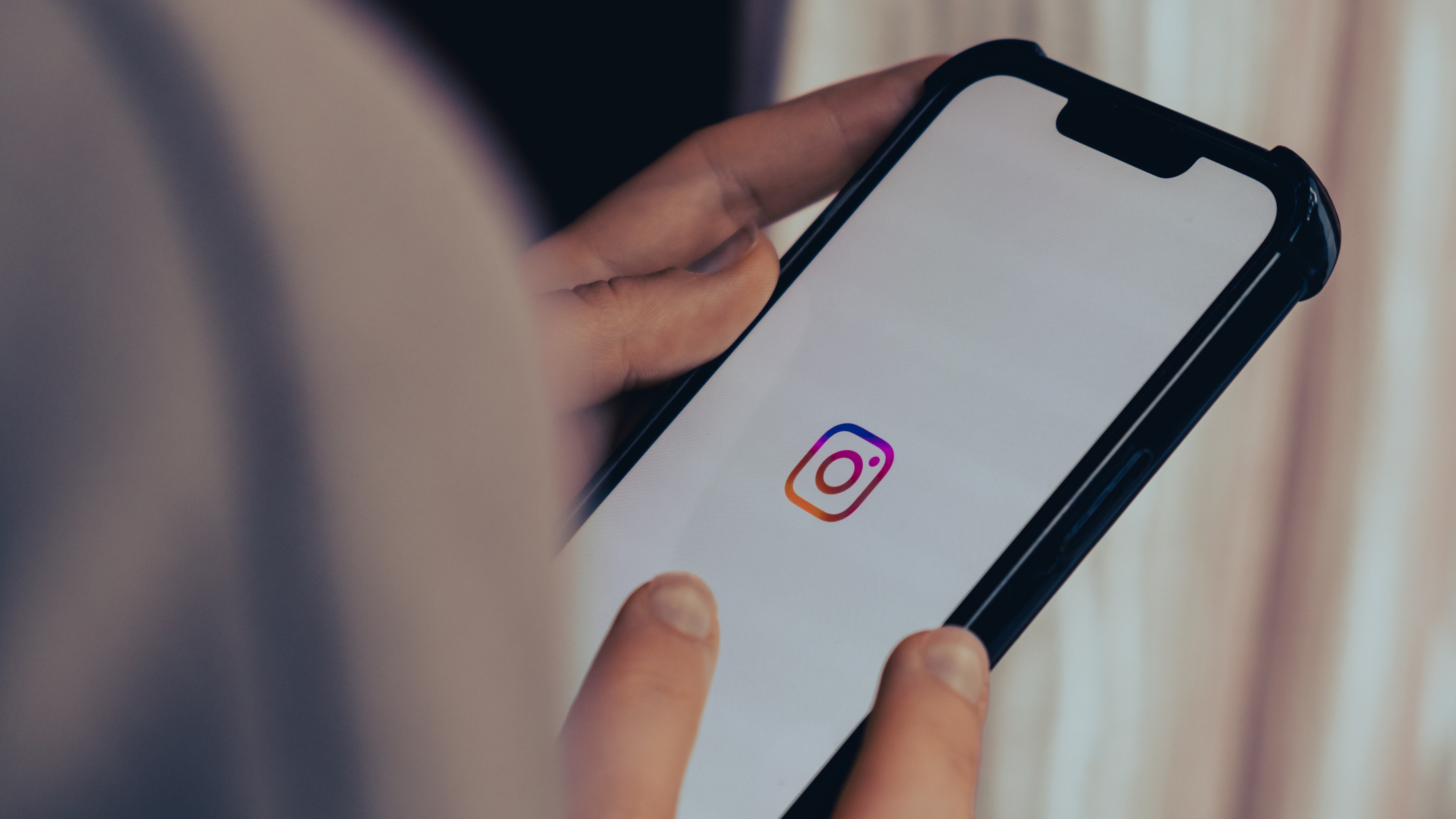 female hand scrolling social media feed on INSTAGRAM.